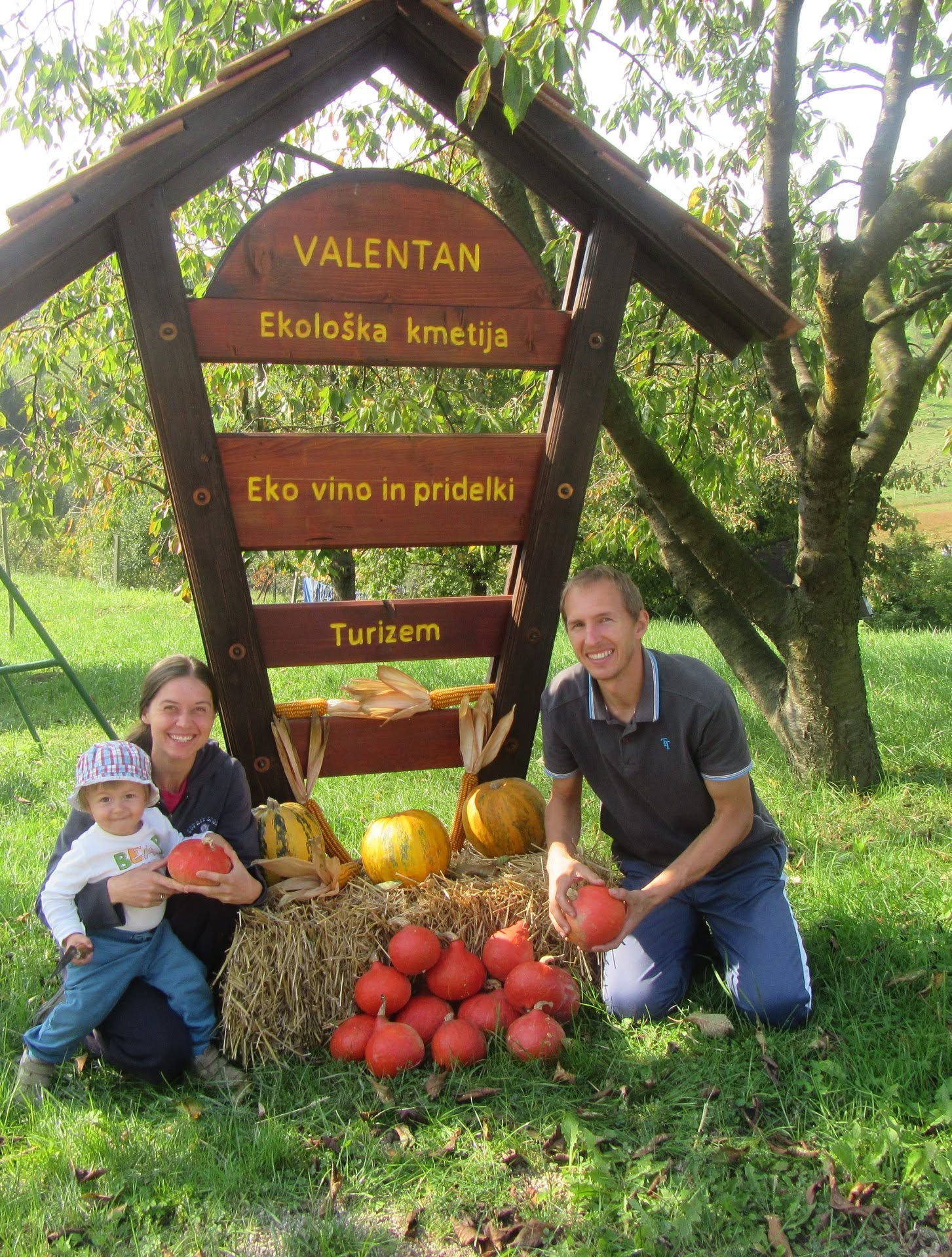 Družina ob znaku ekološke kmetije Valentan